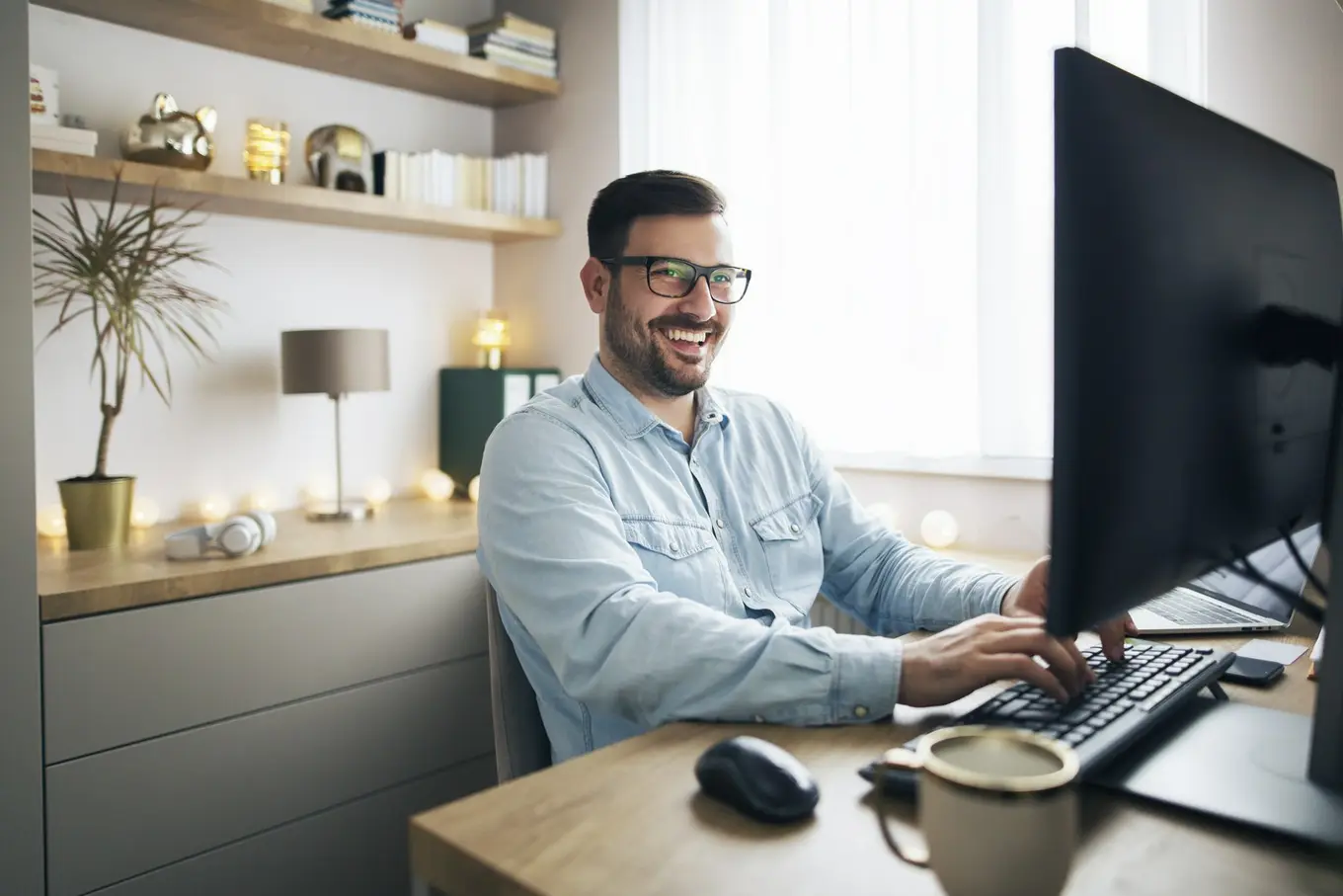 uśmiechnięty mężczyzna przed komputerem